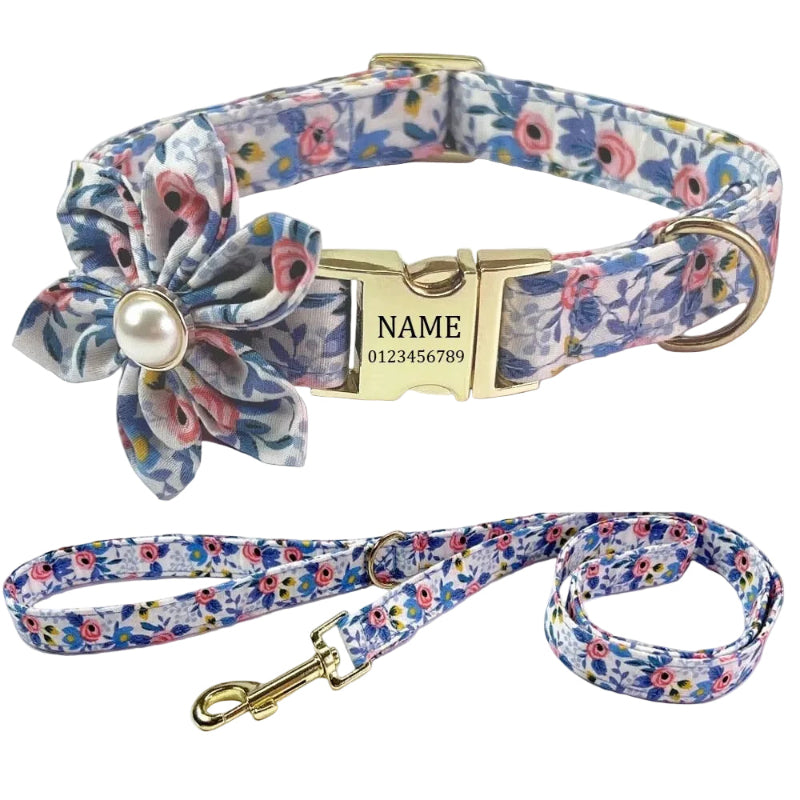 Personalized pet collar and matching leash set with a blue, pink, and white floral print, featuring a gold-tone buckle, D-ring, and clasp, along with a fabric flower accent on the collar.