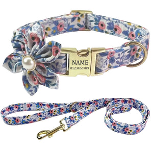 Personalized pet collar and matching leash set with a blue, pink, and white floral print, featuring a gold-tone buckle, D-ring, and clasp, along with a fabric flower accent on the collar.
