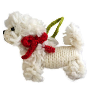White knitted Bichon Frise ornament with a red bow on a white background