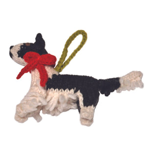 Crocheted Border Collie ornament with a red bow on a white background
