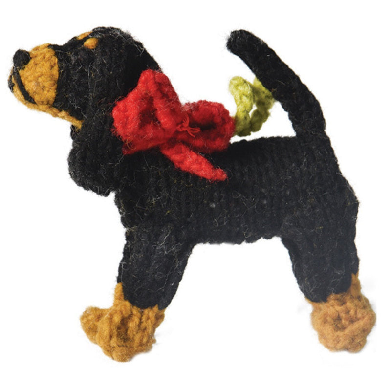 Knitted Coonhound dog ornament with a red bow and green tag on a white background