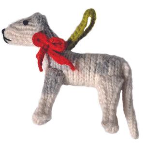 Knitted dog toy with a red bow on a white background