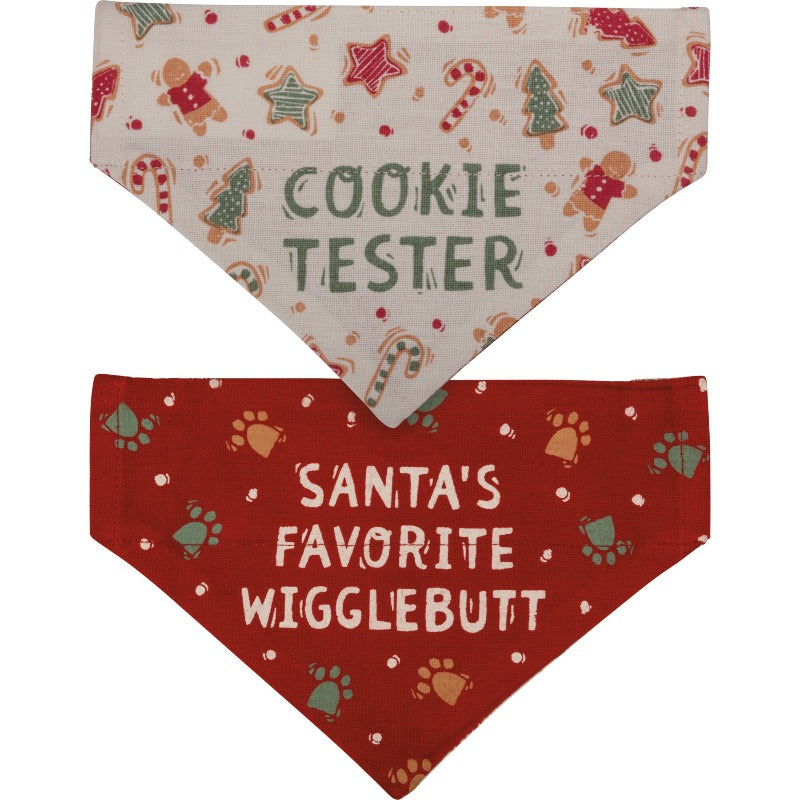 Christmas Reversible Dog Bandana has "Cookie Tester" sentiment with cookie designs on one side on a cream background, and "Santa's Favorite Wigglebutt" sentiment with paw print designs on a red background on the other
