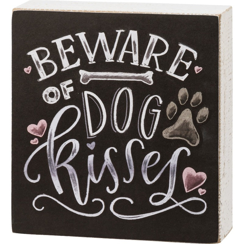 Chalk Sign - Beware Of Dog Kisses white lettering on black background with pink hearts and brown paw print.