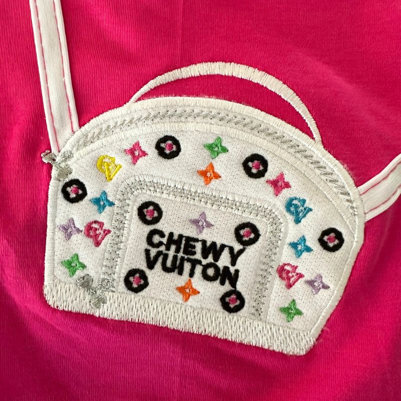 Made of 100% Pima cotton, this designer-inspired embroidered dog T-shirt by Aventura Pups features a Chewy Vuitton white handbag on a hot pink T-shirt.