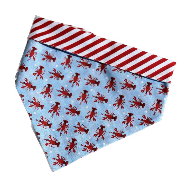 Handmade in the USA by Chloe & Max, this Lobster Bandana features red lobsters on light blue background, with red-and-whilte striped trim and backing. 
