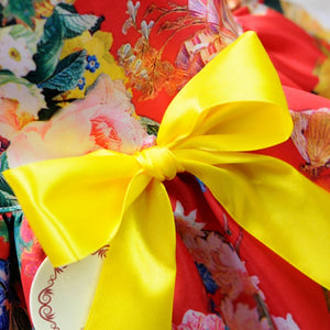 This satin Red Floral Dog Party Dress is adorned with a large yellow bow.